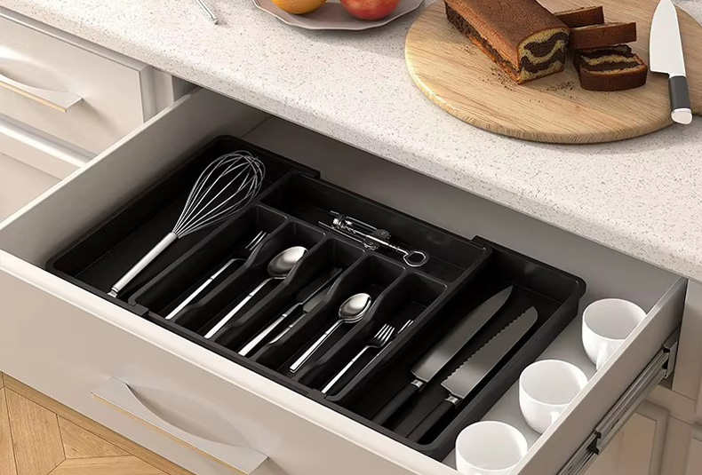 Grabbing cutlery from a PET drawer organizer box in the kitchen