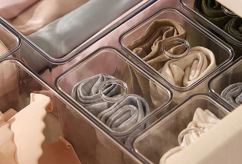 Drawer storage box set organizing clothes inside a dresser drawer